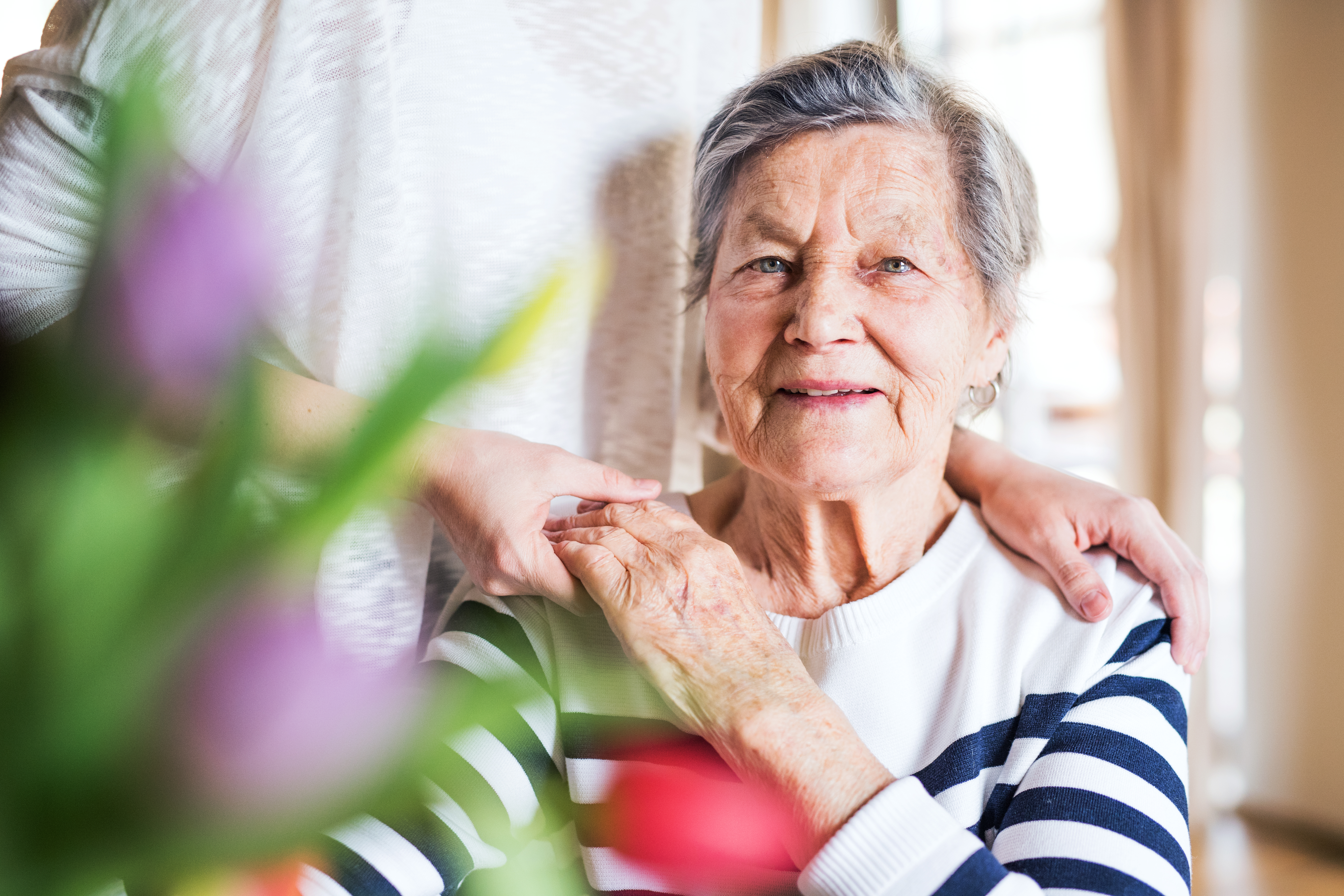 An elderly grandmother with an adult granddaughter at home.
